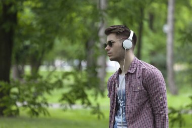 Parkta duran ve müzik genç bir adam portresi. Rahatla ve keyfini çıkar.