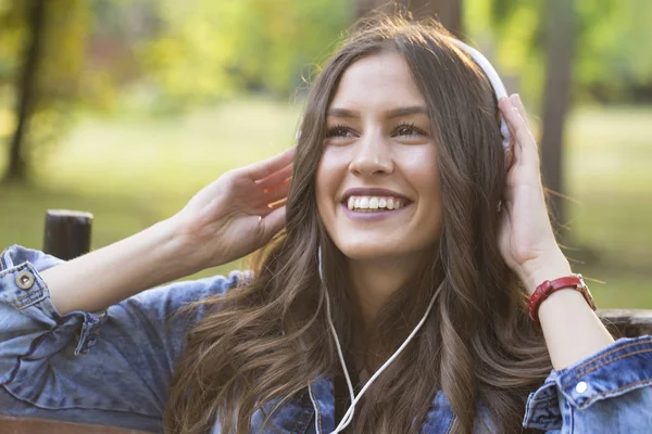 Piękne Młode Uśmiechnięta Kobieta Siedzi Park Ława Słuchanie Muzyki Cieszyć — Zdjęcie stockowe
