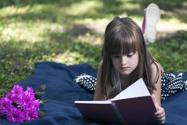 Pequena Menina Bonita Deitada Desfrutar Natureza Enquanto Livro — Fotografia de Stock
