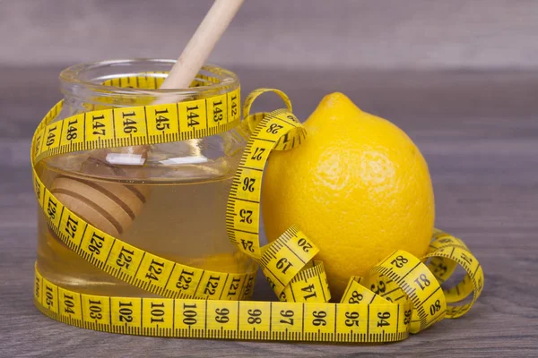 Honey and lemon on a wooden background.The combination of honey and lemon is used for weight loss and for strengthening the immune system of the body.