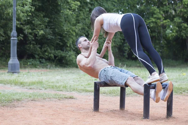 若い幸せなカップル 男と女が公園で運動 彼らは非常に一緒に訓練し アクロバットを実行したいです — ストック写真