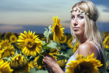 Yaz vaktinizi ayçiçeği alanındaki günbatımında ve taze hava nefes güzel kadın.