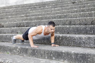 Genç kaslı sporcu gönderme yapıyor açık havada ups. Spor, fitness, sokak egzersiz kavramı