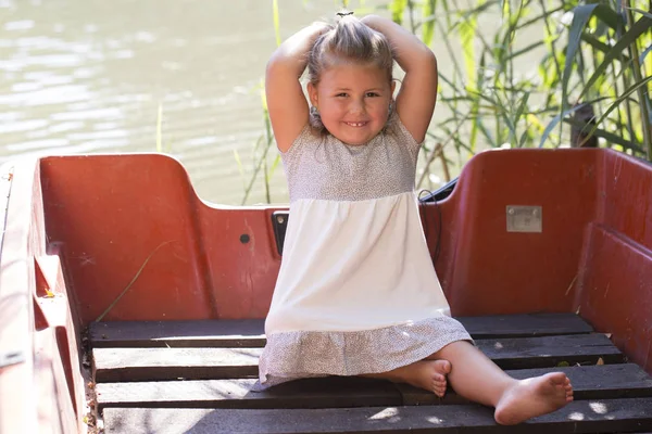 Bir Tekne Bir Göl Kenarında Otururken Bir Sevimli Küçük Kız — Stok fotoğraf