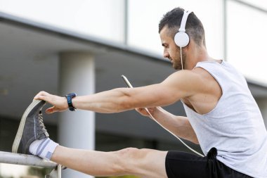 Eğitim parkta hazırlanıyor genç sporcu germe egzersiz yapmak. Egzersiz yaparken, o müzik dinliyor. Fitness, spor, yaşam kavramı