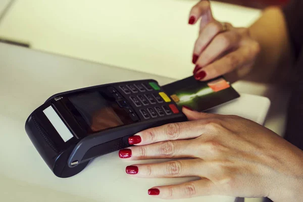 Close up of a seller hands using a dataphone to charge with a credit card in a store desk
