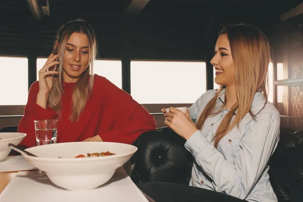 Друзья Женщины Обедают Вместе Ресторане Две Молодые Женщины Пользующиеся Мобильным — стоковое фото