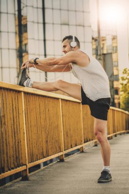 Genç sporcu gerinme egzersizi yapıyor, sabah antrenmanına hazırlanıyor. Fitness, spor, yaşam tarzı konsepti