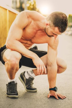 Genç erkek koşucu sporcu antrenmanı yapıyor ve şehir dışında spor yapıyor..