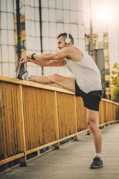 Genç sporcu gerinme egzersizi yapıyor, sabah antrenmanına hazırlanıyor. Fitness, spor, yaşam tarzı konsepti