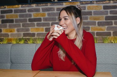 Bir kafede otururken ve kahve içme genç güzel mutlu kadın