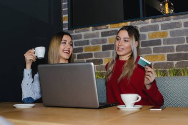 Bir kafede iki arkadaş hatta bir dizüstü bilgisayar ve bir kredi ile satın alma kartı