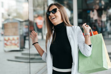 Alışveriş torbaları bol açık havada güzel genç kadın. Sürpriz yüz trendy kıyafetler kadında genç Alışverişkoliğin portresi.