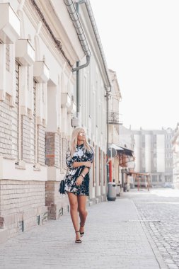 Sokakta yürürken güneş gözlüklü siyah elbiseli güzel bir genç çekici kadın portresi