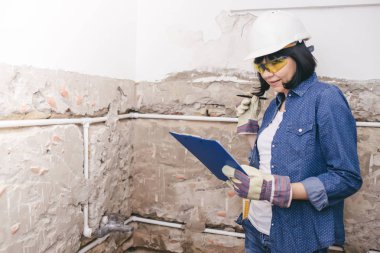 Kadın inşaat işçisi planlama nasıl banyo lavabo boru olumlu tutum ile onarmak için. bir iş aracı kullanarak. 