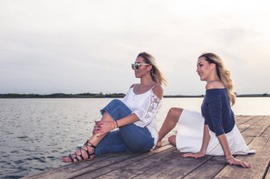 Yaz saati. Nehir kenarında oturan iki genç arkadaşlar. Yaz akşamları joying .