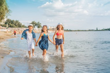 Yaz tatillerini beach resort, seyahat ve Turizm kavramı üzerinde zevk denizde su sıçramasına zevkle mutlu neşeli küçük çocuklar oynarken