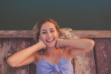 Ahşap iskele sahilde yatan çekici gülümseyen genç kadın. Güzel kız Gölü yanında poz. Yukarıdan bakmak