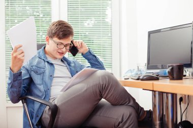 Cep telefonu üzerinde konuşurken ve onun çalışma evinde otururken belge arıyorum genç yakışıklı adam