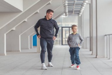 Küçük bir çocuk ve babası birlikte bir spor merkezinde egzersiz. Baba ve oğul birlikte vakit ve sağlıklı bir yaşam tarzı yol. Birlikte çalışma dışarı. Fitness gün. Sportif aile kavramı. Aktif yaşam tarzı