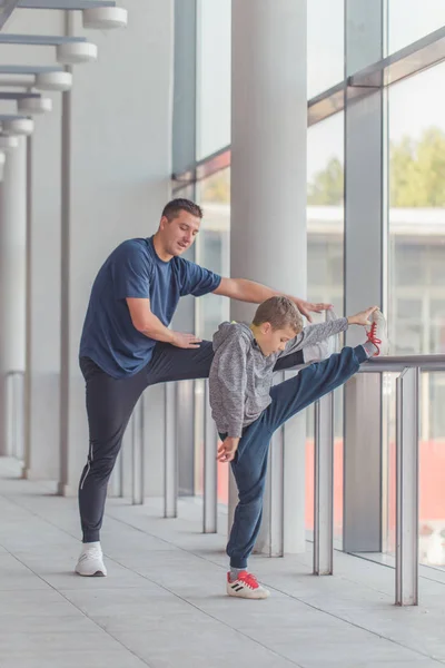 Μικρό Αγόρι Και Εκπαιδευτής Κάνει Ασκήσεις Stretching Ποδιών Μαζί Στο — Φωτογραφία Αρχείου