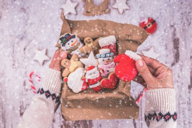 Noel hediye gingerbread ahşap arka plan üzerinde. Bisküvi şenlikli ambalajında. Kadın Noel gingerbread çerezleri bir kutu ambalaj. Üstten görünüm. Kopya alanı