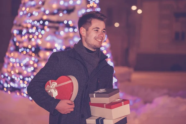 Young handsome man with presents in the city