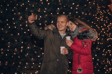 Selfie yapma ve Noel arka plan - IMAG ayakta iken gülümseyen mutlu genç sevgi dolu çift