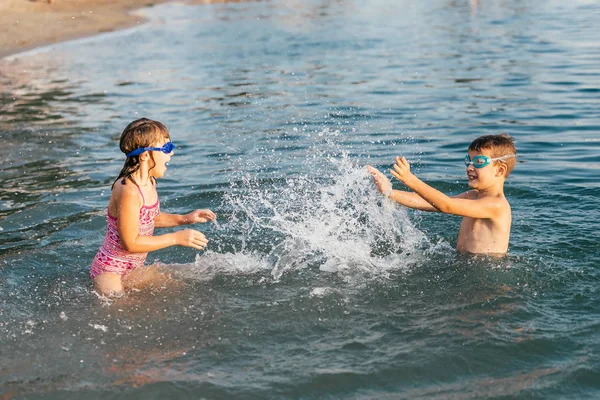 幸せな子供が海で遊んでいます 子供たちは屋外の楽しい時を過します 夏休み 家族や健康的なライフ スタイルのコンセプト — ストック写真