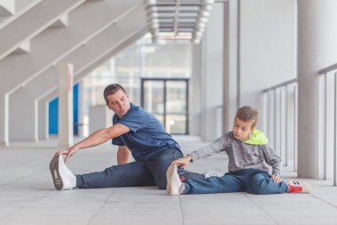 Küçük bir çocuk ve babası birlikte bir spor merkezinde egzersiz. Baba ve oğul birlikte vakit ve sağlıklı bir yaşam tarzı yol. Birlikte çalışma dışarı. Fitness gün. Sportif aile kavramı. Aktif yaşam tarzı
