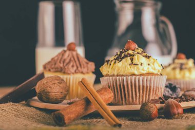 Bir çikolatalı kek kek kek ve bir bardak süt arka planda - görüntü ile ahşap bir gemide closeup