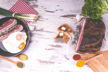 Kızarmış yumurta kızartma tavası, pastırma, kızarmış ekmek, salata ve baharat ahşap rustik arka plan üzerinde. Çok lezzetli yemek. Üstten görünüm. Kopyala Yapıştır