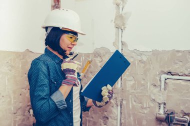 Kadın inşaat işçisi planlama nasıl banyo lavabo boru olumlu tutum ile onarmak için. bir iş aracı kullanarak. 