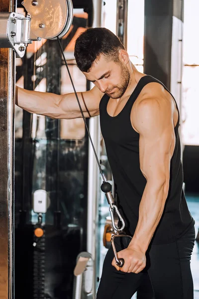 Uomo muscolare che lavora in palestra facendo esercizi a tricipiti — Foto Stock