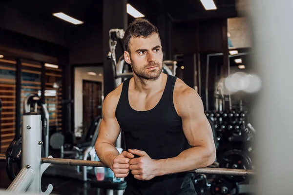 Genç adam bir spor salonunda egzersiz sonra dinlenme