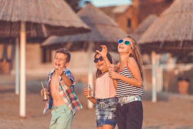 Çocuklar sahilde eğleniyor.