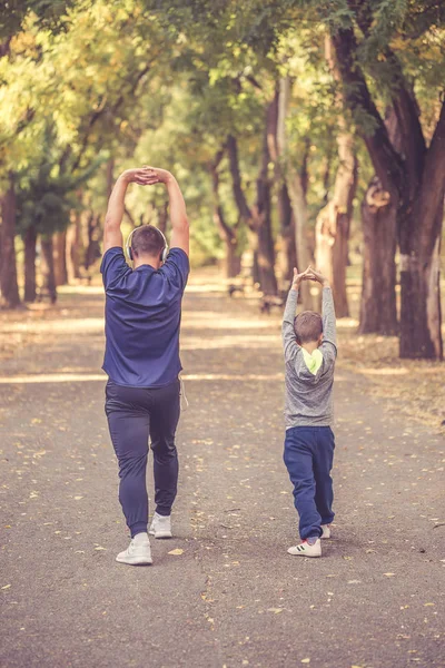 Pai e seu filhinho exercitando juntos no parque — Fotografia de Stock