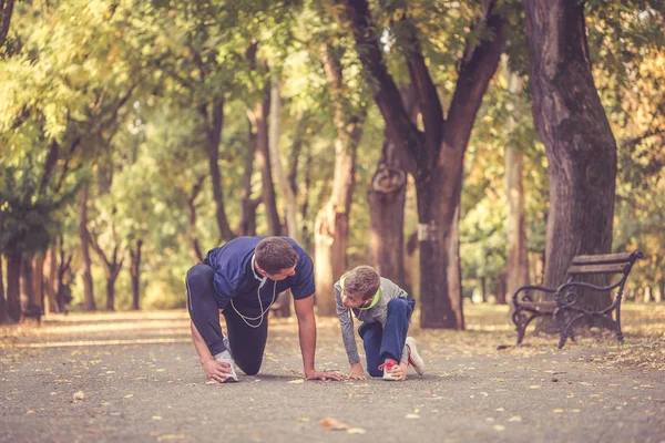 Pai e filho pequeno se exercitando juntos no parque — Fotografia de Stock