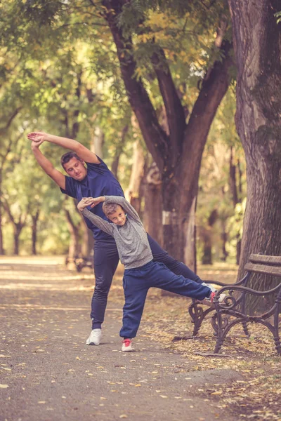 Padre e hijo haciendo ejercicio juntos en el parque — Foto de Stock