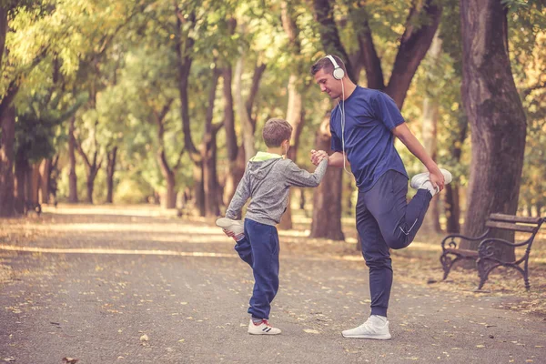 Malý chlapec a jeho otec cvičení spolu venku — Stock fotografie