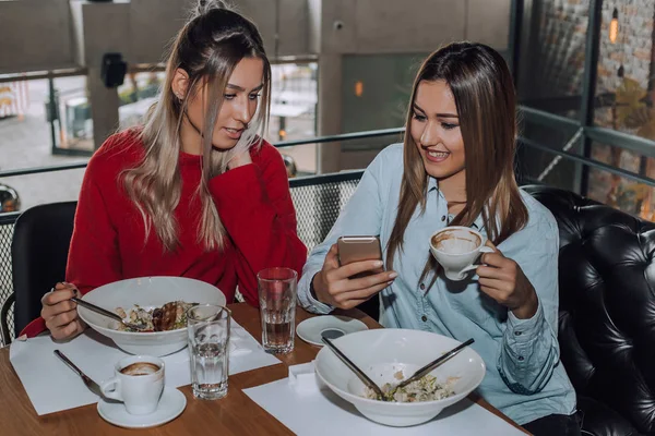 Due amiche che usano il cellulare durante il pranzo — Foto Stock