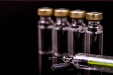 Bir şırınga ve siyah ampul için tıbbi şişeleri 