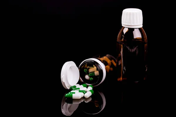 Butelka szklana z kolorowych kapsułek i syrop lek — Zdjęcie stockowe
