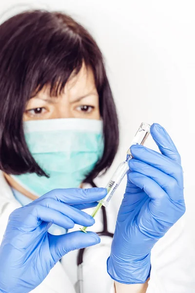 Kvinnliga läkare håller sprutan och ampull — Stockfoto