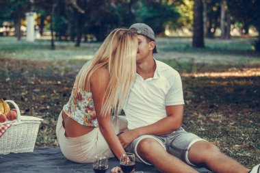 Mutlu genç çift bir parkta romantik piknik sırasında öpüşme