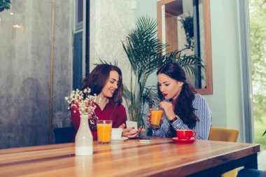 İki genç kadın suyu içme ve akıllı p bir şey izliyor