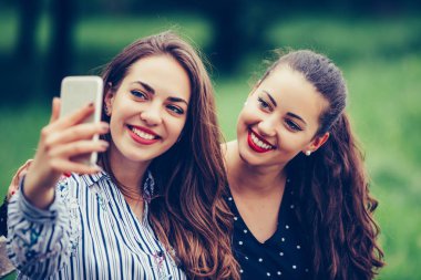 İki güzel genç kadın açık havada selfie yapıyor