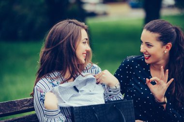  Alışveriş ve paylaşımdan sonra parkbankında oturan iki kadın 