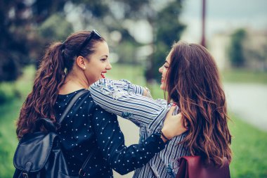 Birbirine sarılarak iki güzel kadın arkadaş geri görünümü w
