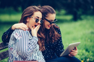 Dijital tablet kullanan iki güzel kadın arkadaş wi şaşırttı